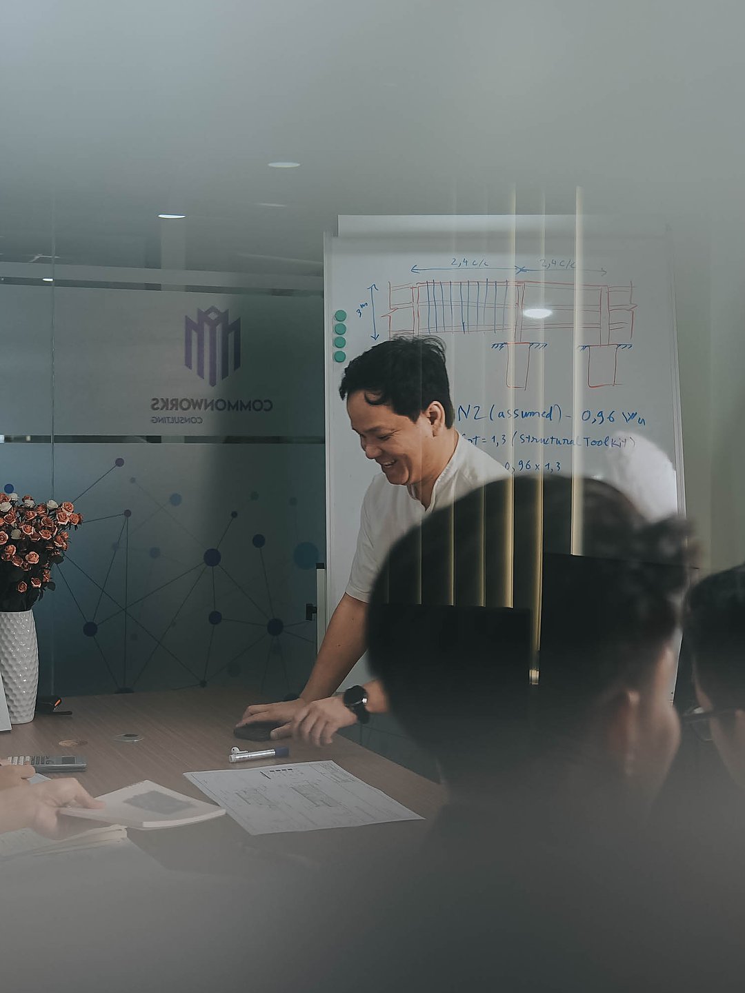 The CommonWorks team working through a structural detail at the whiteboard